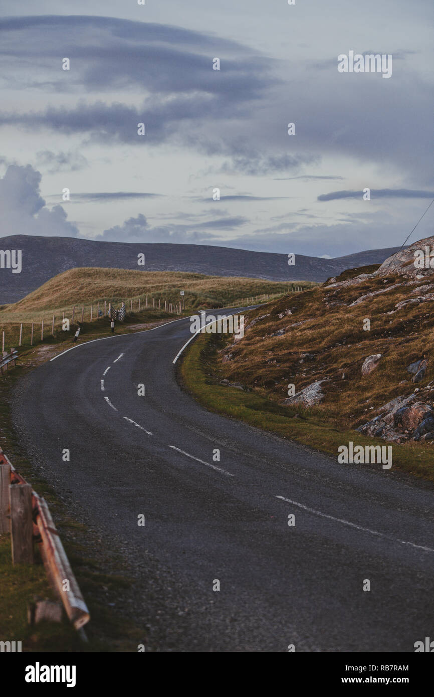 Isle of Harris : an empty road se tordant autour des Hébrides extérieures paysage sur la partie sud de l'îles de Lewis et Harris, Scotland, UK Banque D'Images