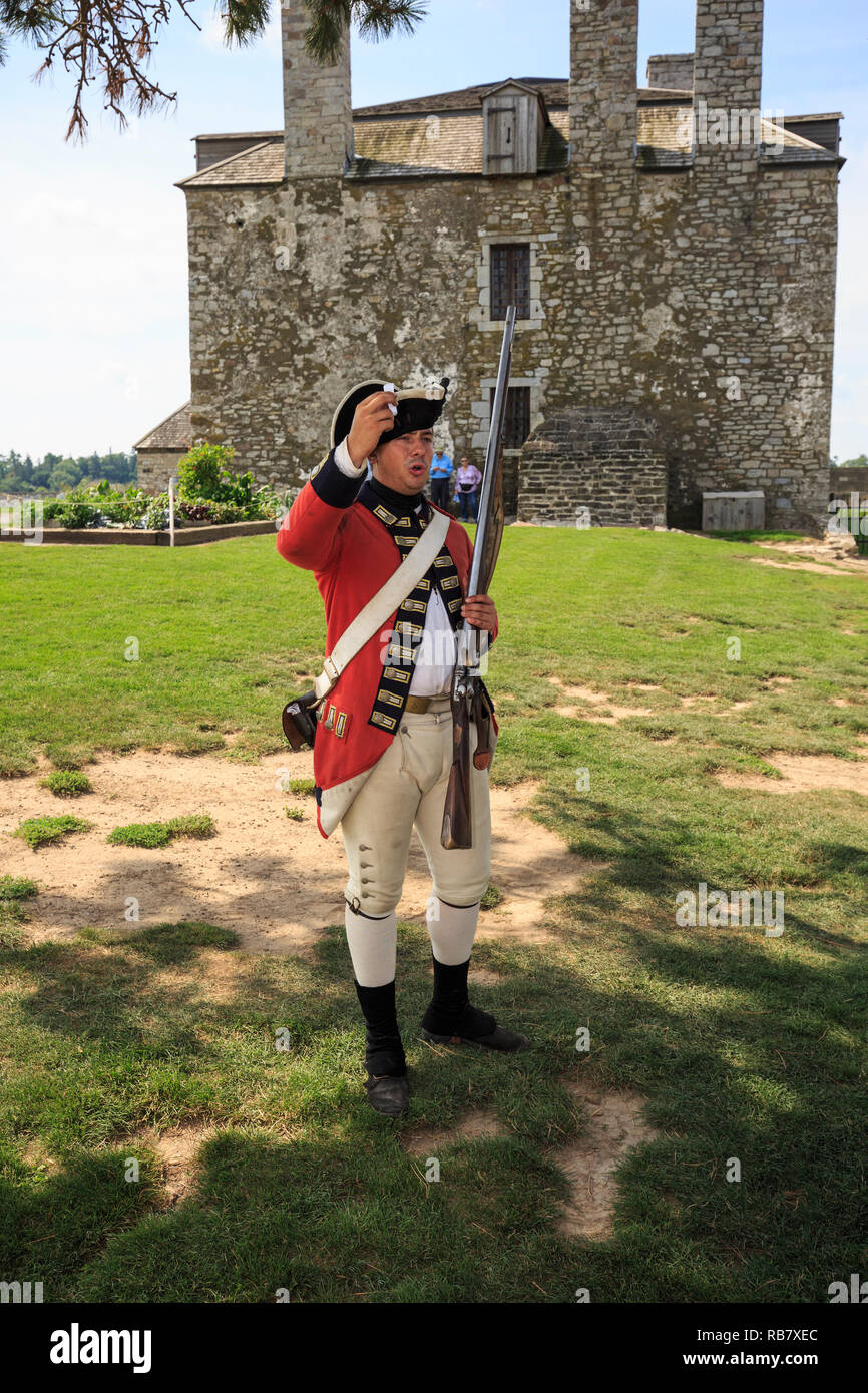 18 ème siècle soldat britannique reenactor démontrant les étapes de chargement et de tir pour un mousquet au fort Niagara State Park à New York Banque D'Images