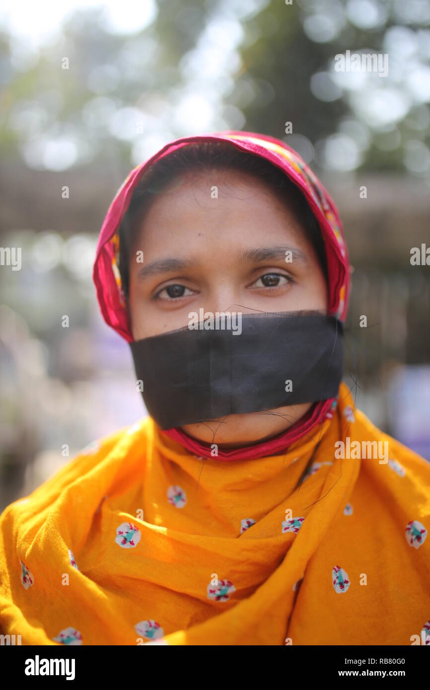 Activiste de gauche du Bangladesh à l'Alliance démocratique porte de tissu noir sur sa bouche pendant un meeting de protestation à la demande ré-élection sous gouvernement intérimaire non partisane à Dhaka, Bangladesh, le 3 janvier 2019. Asad Rehman © / Alamy Stock Photo Banque D'Images