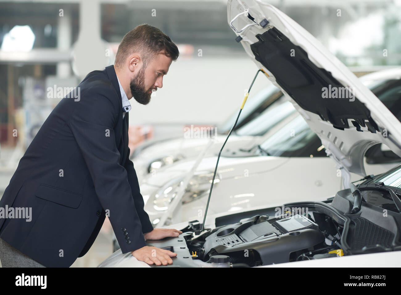 Homme regardant sous le capot de la voiture Banque de photographies et ...