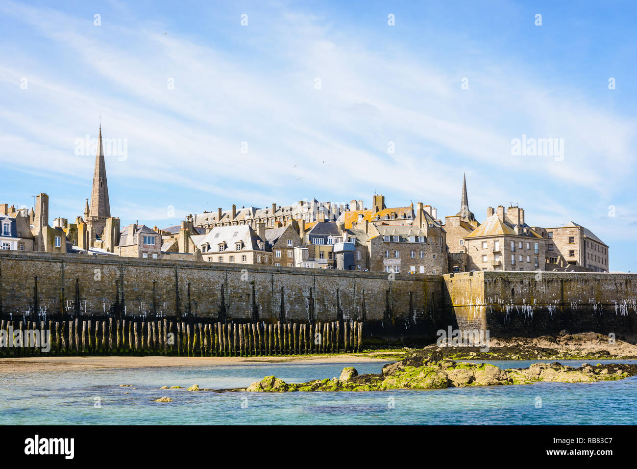 La vieille ville de Saint-Malo en Bretagne avec le clocher de la cathédrale et les bâtiments dépassant le mur de la ville par un matin ensoleillé. Banque D'Images La vieille ville de Saint-Malo en Bretagne avec le clocher de la cathédrale et les bâtiments dépassant le mur de la ville par un matin ensoleillé. Banque D'Images