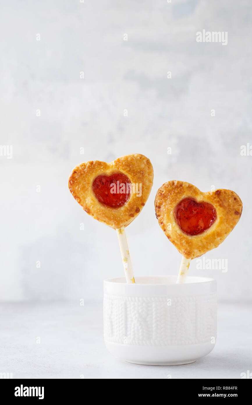 Sablés faits maison sur un bâton. Des bonbons en forme de coeur pour la Saint-Valentin. Banque D'Images
