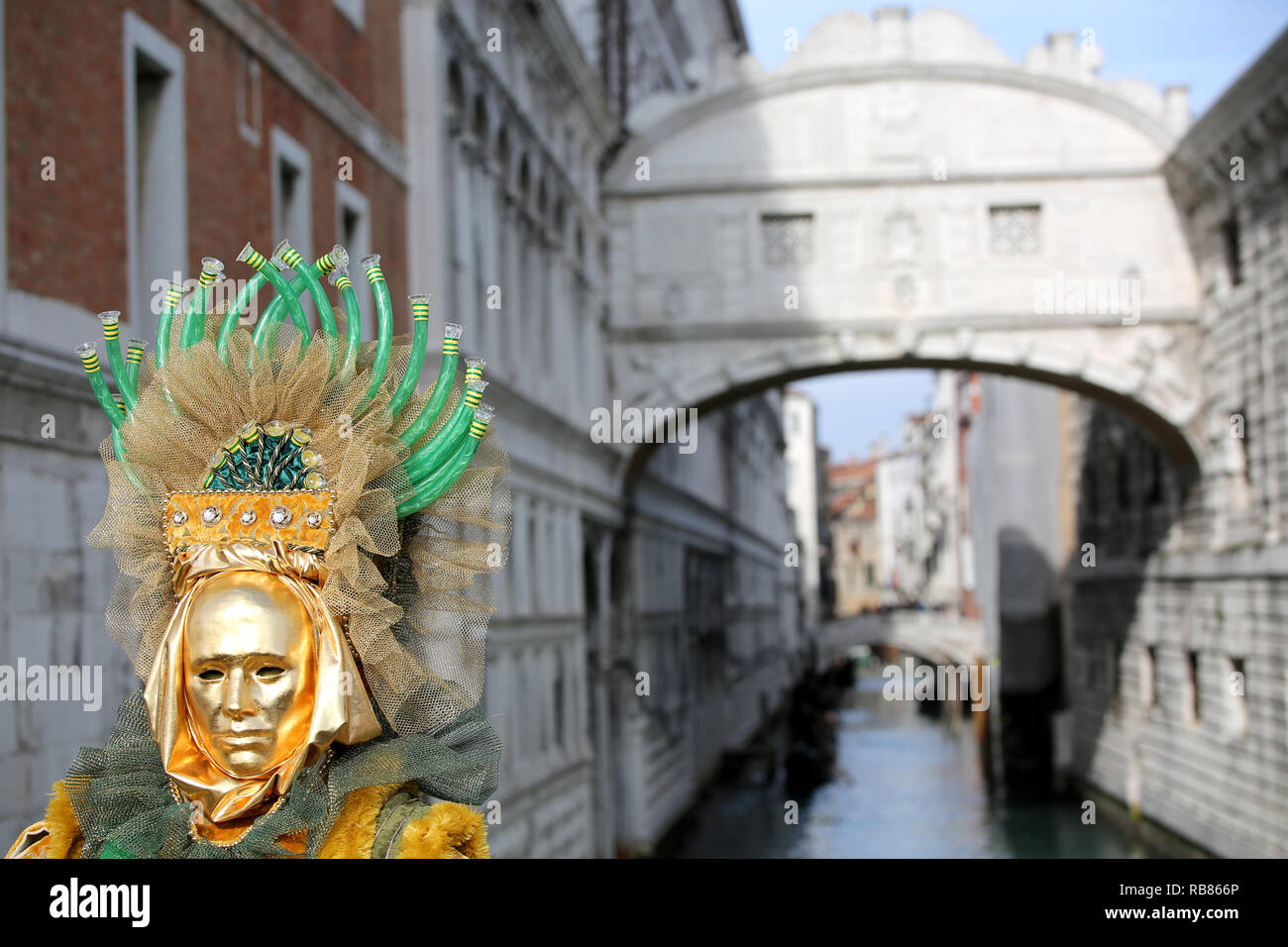 Venezia, VE, Italie - 5 Février 2018 : Personne avec masque d'or et le Pont des Soupirs et du Palais ducal Banque D'Images
