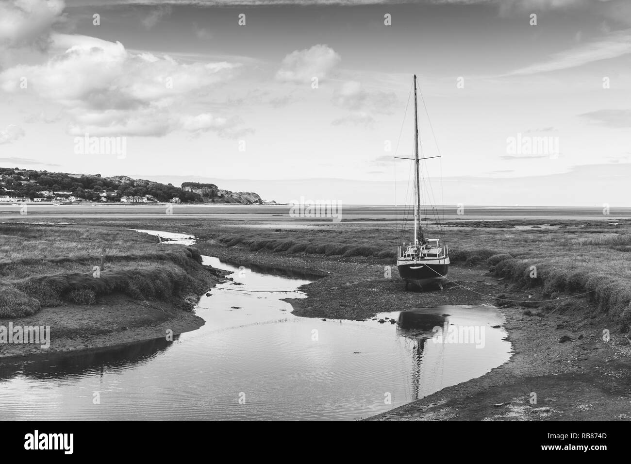 Un bateau amarré en attendant la marée rouge dans la baie de quai, Anglesey Banque D'Images