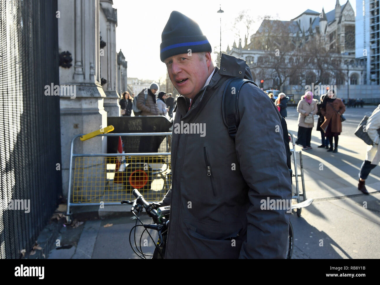 Boris Johnson MP pousse sa bicyclette dans les chambres du Parlement à Londres. Banque D'Images