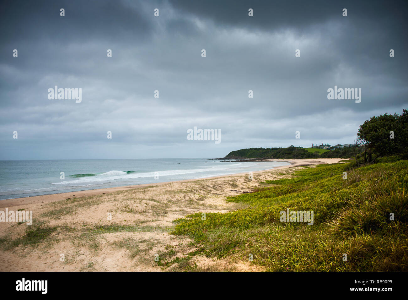 Diamond Beach sur la côte centrale, New South Wales, Australie. Scène à couper le souffle, forêt pluviale côtière répond aux dunes de sable avec un fond de ciel orageux Banque D'Images