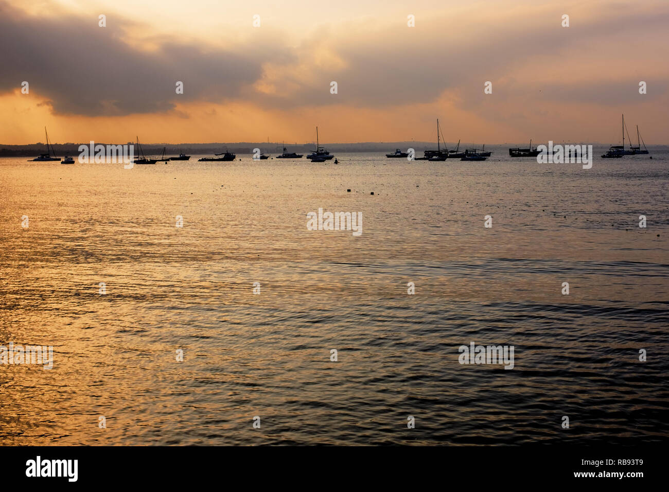 Yachts et voiliers à l'ancre sur une suspension de l'océan toujours au coucher du soleil près du Yacht Club sur la côte de Dar es Salaam, Tanzanie Banque D'Images