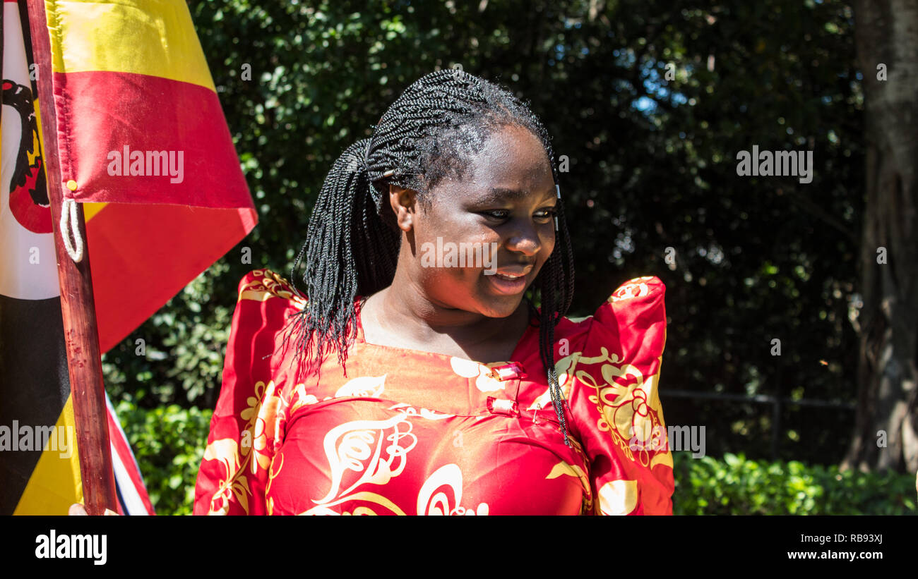 Une photo d'une jeune femme brandissant un drapeau ougandais Banque D'Images