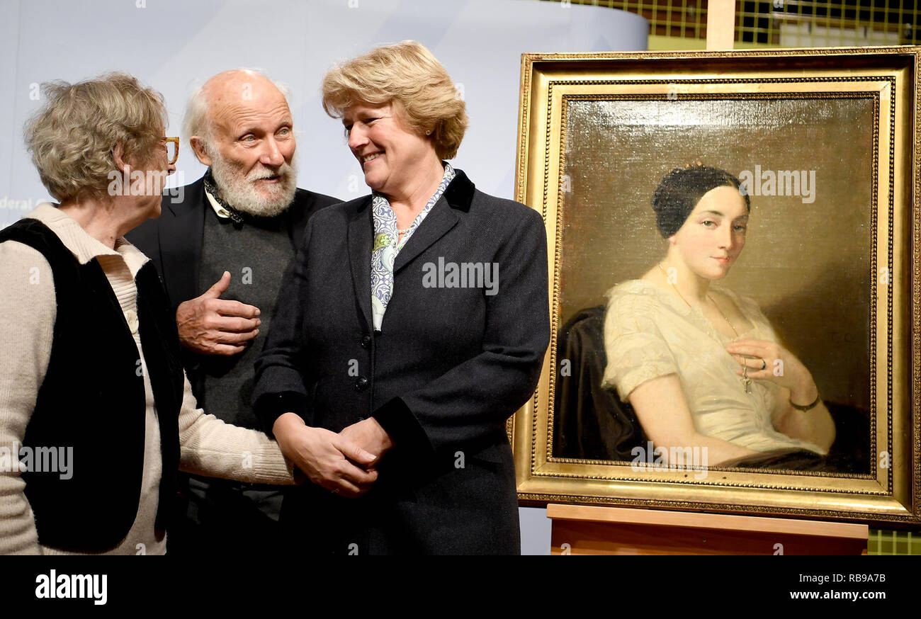 Berlin, Allemagne. 05Th Jan, 2019. Monika Grütters (CDU, r), Ministre d'État à la culture, les mains sur la peinture 'Portrait d'une jeune femme assise/Portrait de jeune femme assise" par l'artiste Thomas Couture pour les héritiers Maria de las Mercedes, Estrada et Wolfgang Kleinertz. La peinture de l'art trouver Gurlitt a été identifié comme étant l'art pillés par les Nazis et est retourné aux descendants. Credit : Britta Pedersen/dpa-Zentralbild/dpa/Alamy Live News Banque D'Images