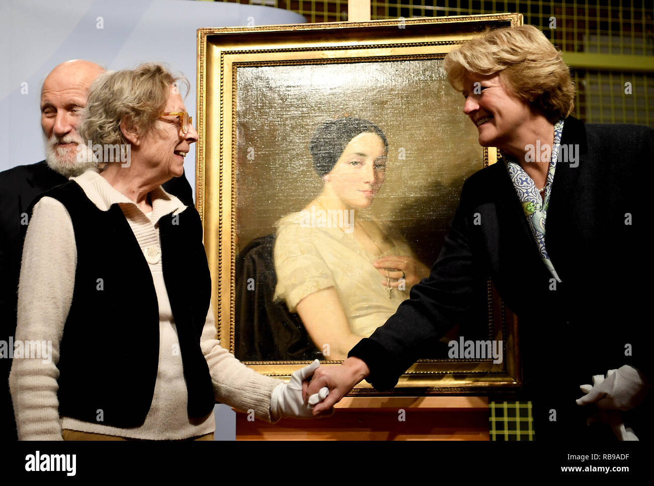 Berlin, Allemagne. 05Th Jan, 2019. Monika Grütters (CDU, r), Ministre d'État à la culture, les mains sur la peinture 'Portrait d'une jeune femme assise/Portrait de jeune femme assise" par l'artiste Thomas Couture pour les héritiers Maria de las Mercedes, Estrada et Wolfgang Kleinertz. La peinture de l'art trouver Gurlitt a été identifié comme étant l'art pillés par les Nazis et est retourné aux descendants. Credit : Britta Pedersen/dpa-Zentralbild/dpa/Alamy Live News Banque D'Images