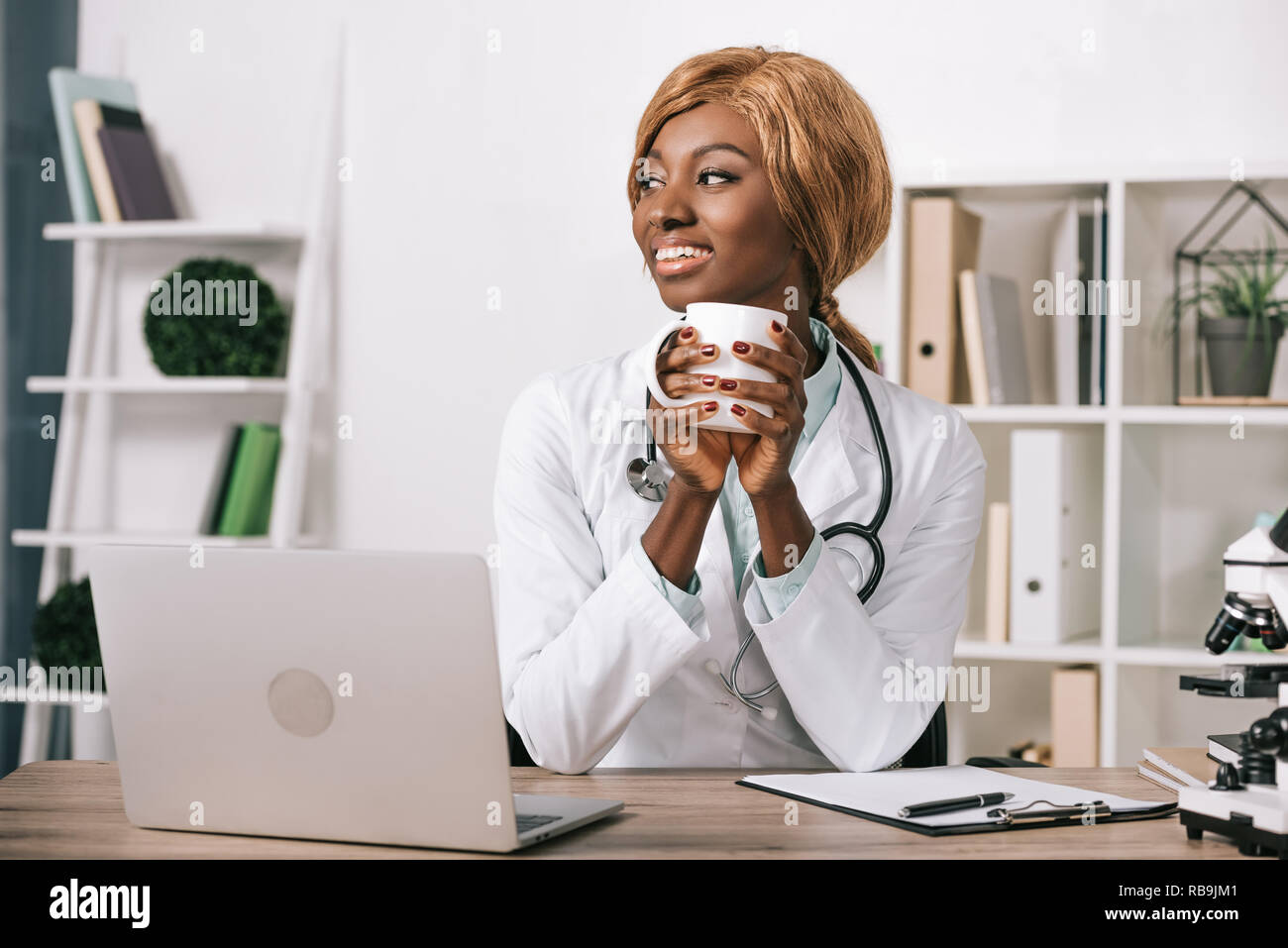 African American female scientist holding cup Banque D'Images