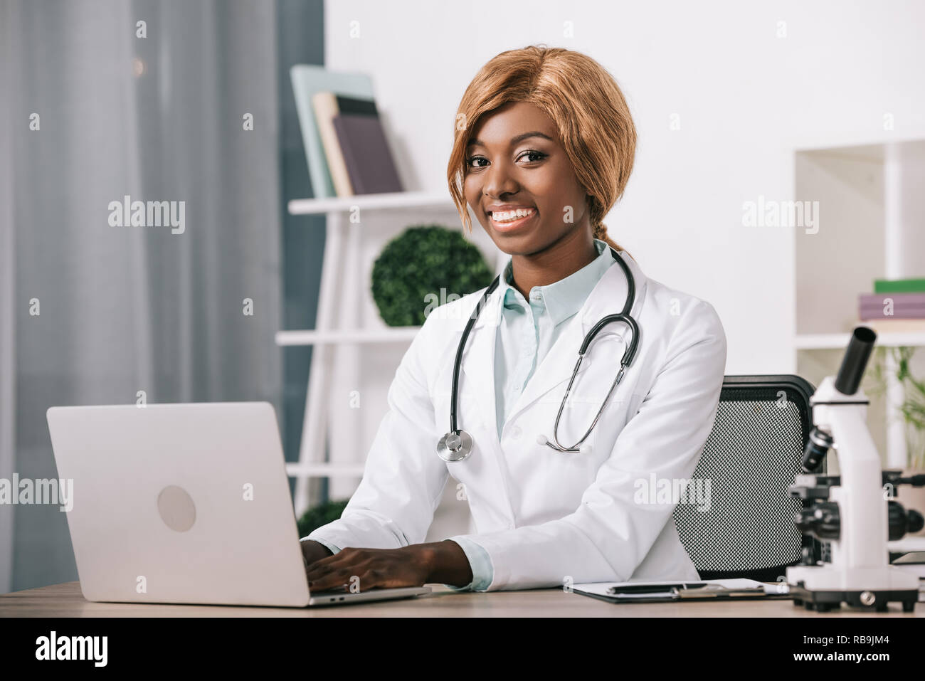 Le scientifique américain africain femme gaie typing on laptop Banque D'Images