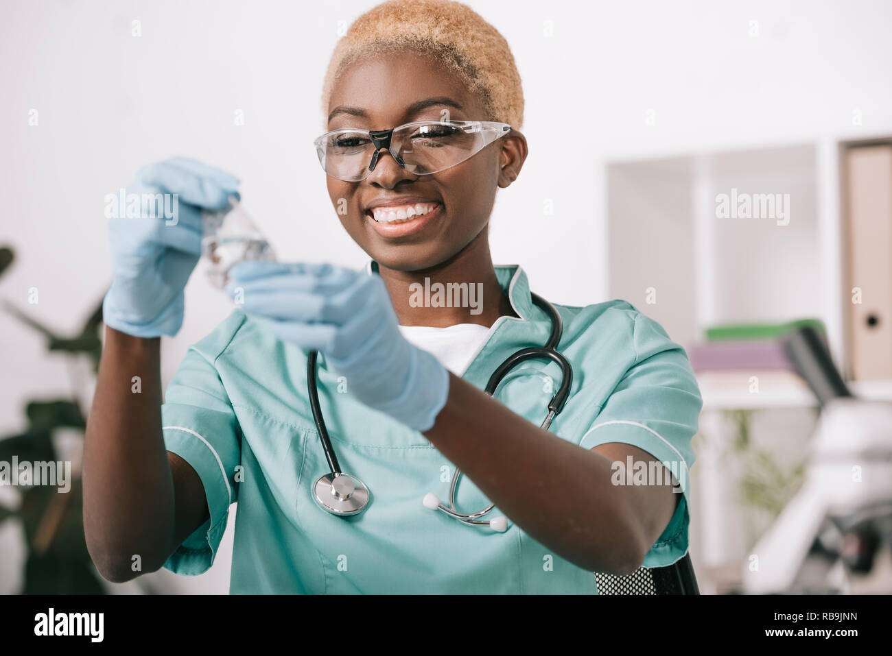 Smiling african american scientist holding flacon de laboratoire Banque D'Images