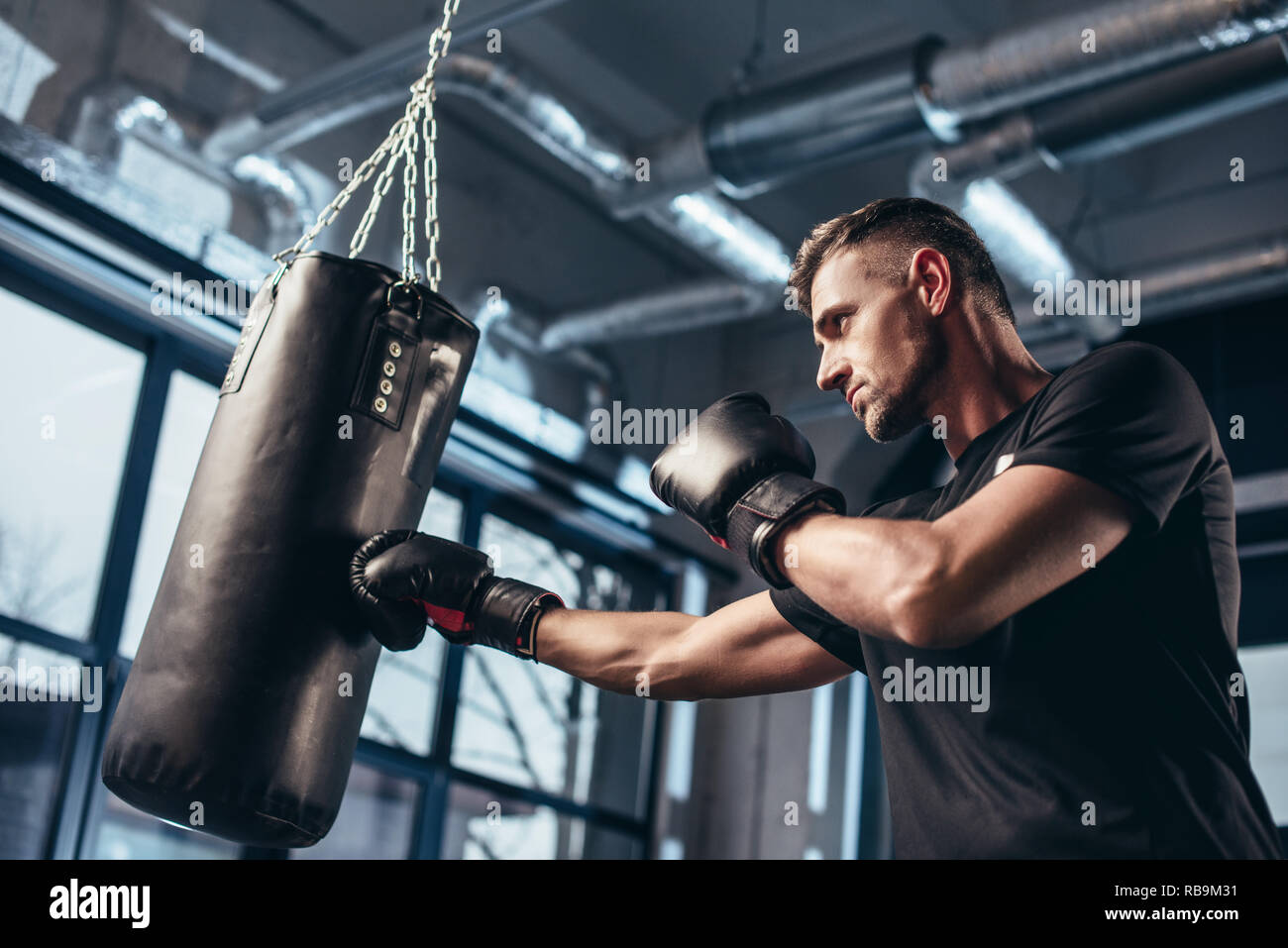 Low angle view of handsome boxer sac de frappe avec la formation en salle  de sport Photo Stock - Alamy