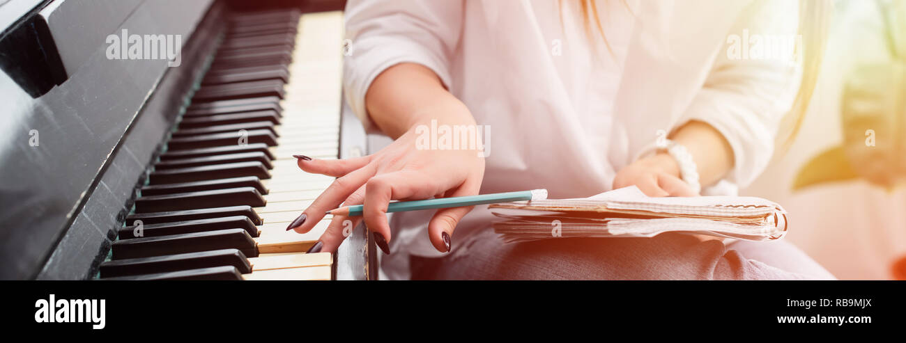 Portrait de jeune fille avec un ordinateur portable à jouer du piano et composer de la musique à la maison avec l'afficheur Banque D'Images