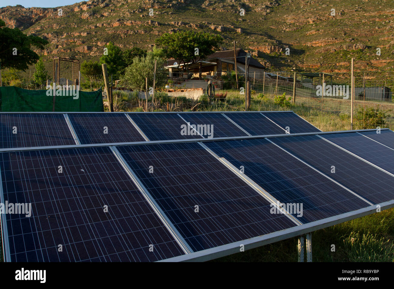 Vivant hors de la grille : des panneaux solaires fournissent l'électricité pour la maison de ferme à l'arrière-plan. Banque D'Images