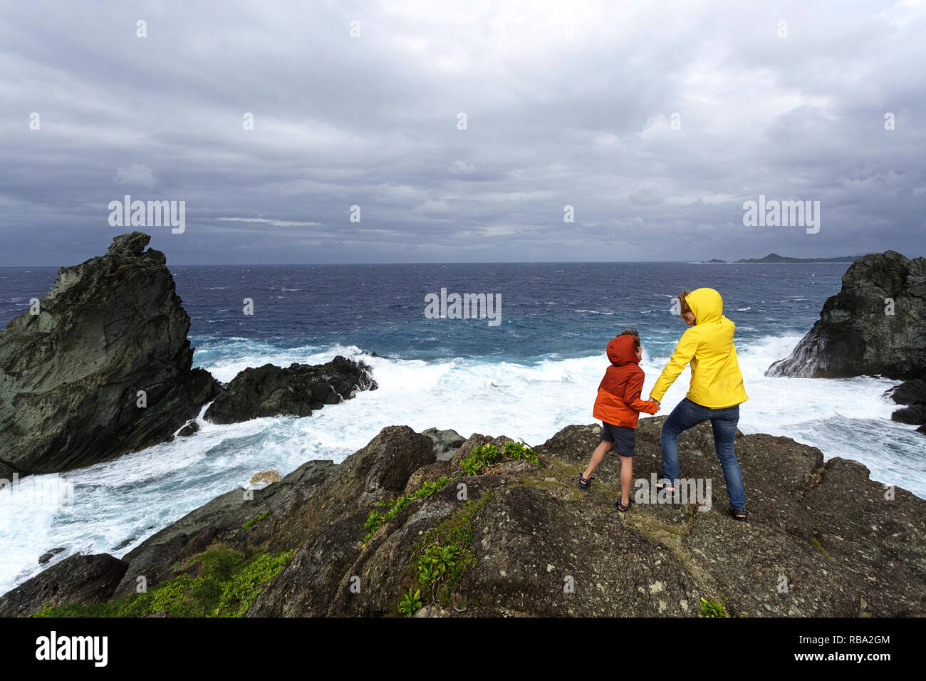 La mère et le fils à la recherche à l'état de la mer sur la côte sauvage à Uganzaki dans le phare de l'Île Ishigaki, Japon Okinawa Banque D'Images