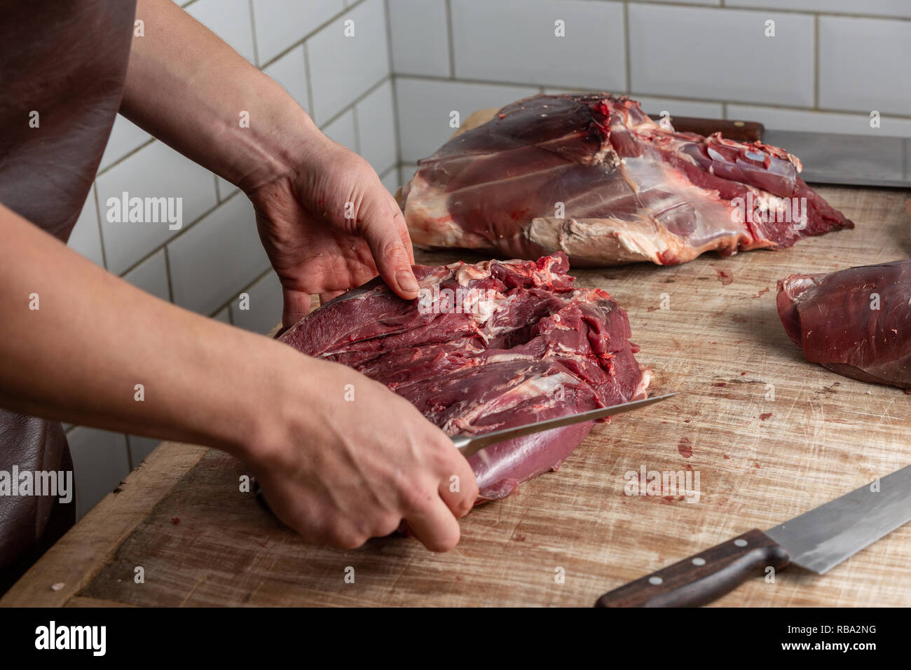 La préparation de la viande de venaison boucher au Gog Farm Shop, Stapleford, Cambridge, Cambridgeshire Banque D'Images