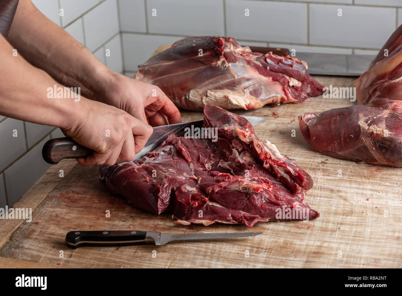 La préparation de la viande de venaison boucher au Gog Farm Shop, Stapleford, Cambridge, Cambridgeshire Banque D'Images