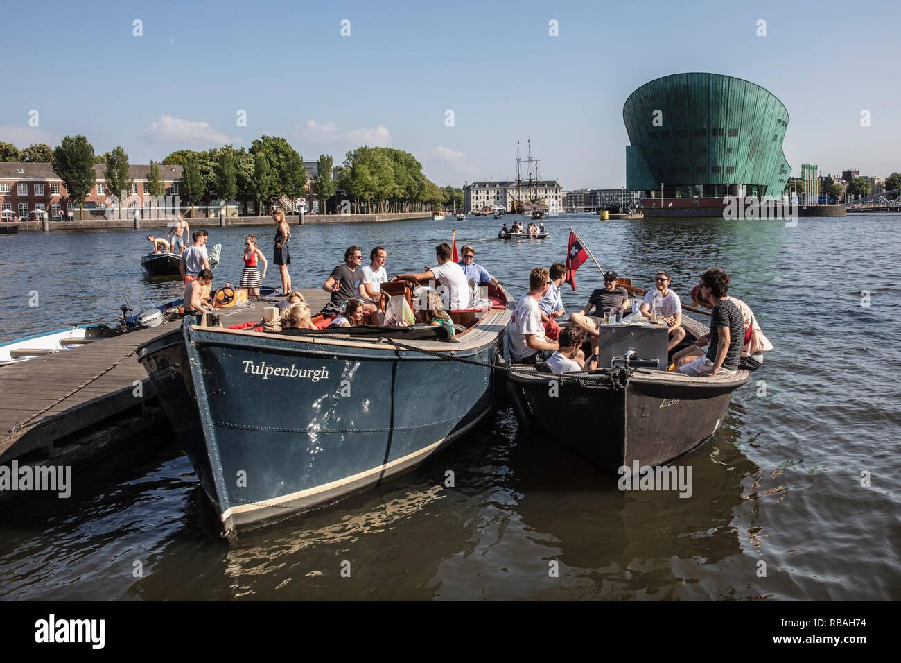 Les Pays-Bas, Amsterdam. Jetée du restaurant Hannekes Boom près de la gare centrale. Contexte National Maritime Museum et musée scientifique Nemo. Banque D'Images