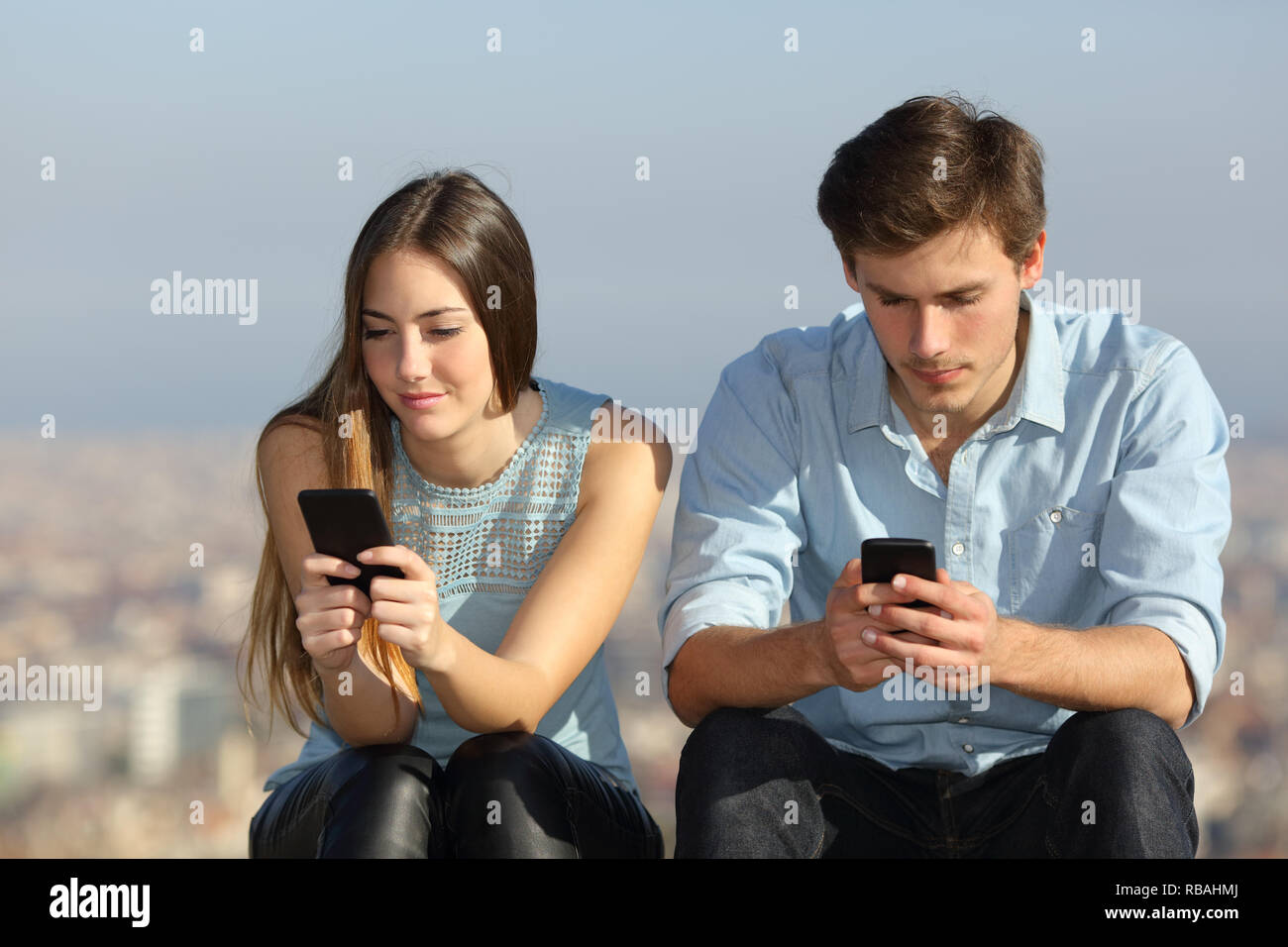 Deux téléphones intelligents une dépendance à l'ignorant dans une ville périphérie Banque D'Images