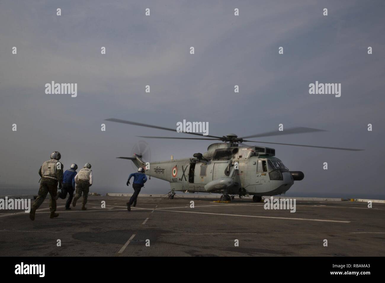 Les Marines américains avec la 13e Marine Expeditionary Unit (MEU) et les marins de la marine avec le groupe amphibie d'Essex (ARG) de la San Antonio-classe de transport amphibie USS dock Anchorage (LPD 23) L'approche qu'une marine indienne UH-3H hélicoptère pour enlever les chaînes alors que d'ancrage et entrepris 13e MEU participer à un déploiement de coopération avec le navire indien, INS Rajput (D51), de tester leur capacité de communiquer et d'améliorer les capacités maritimes entre partenaires, 26 Décembre, 2018. L'ancrage est déployé dans le cadre de la Essex ARG Groupe amphibie (ARG). L'Essex et ARG 13e MEU sont un capab Banque D'Images