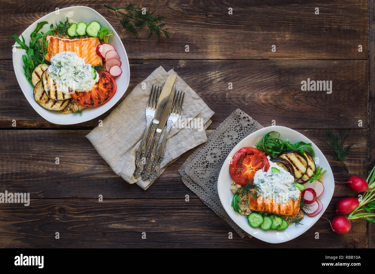 Saumon grillé, tomates et aubergines avec le quinoa et sauce tzatziki sur fond de bois rustique. Dîner sain. Vue d'en haut. Banque D'Images