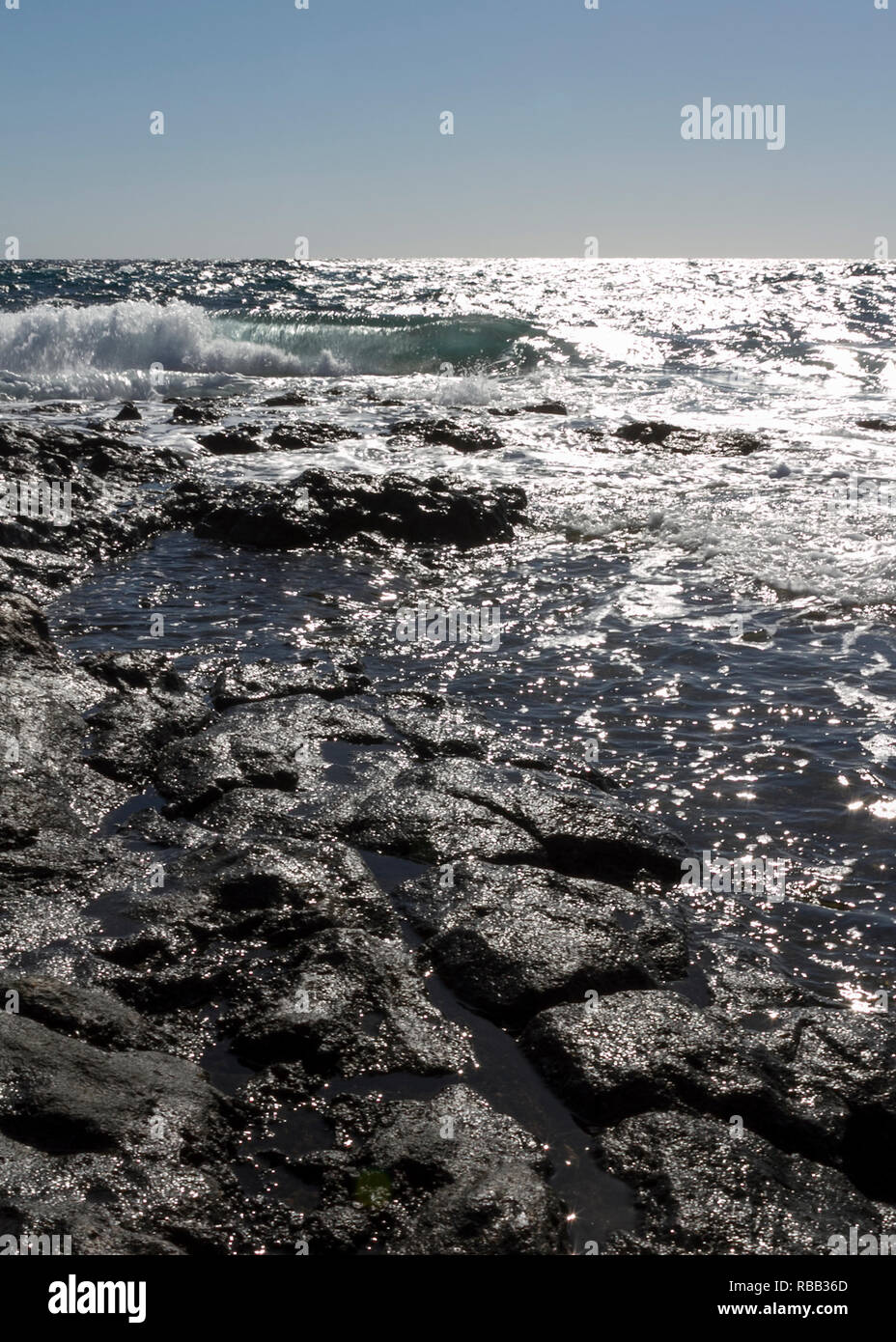 La mer turquoise plante vagues contre la rive de Lanzarote, à proximité de Costa Teguise. La mer rencontre le ciel avec un horizon lointain. Banque D'Images