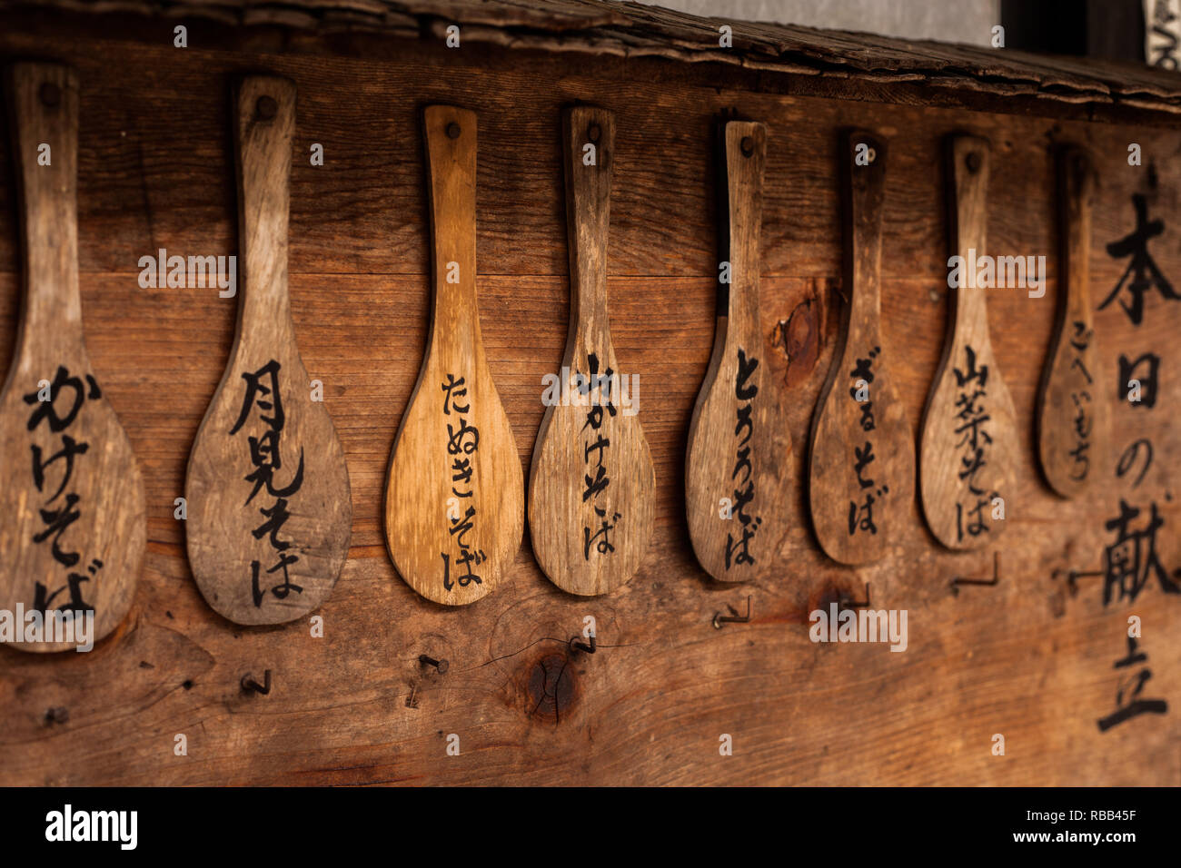 L'écriture japonaise sur les cuillères en bois accroché au mur Banque D'Images