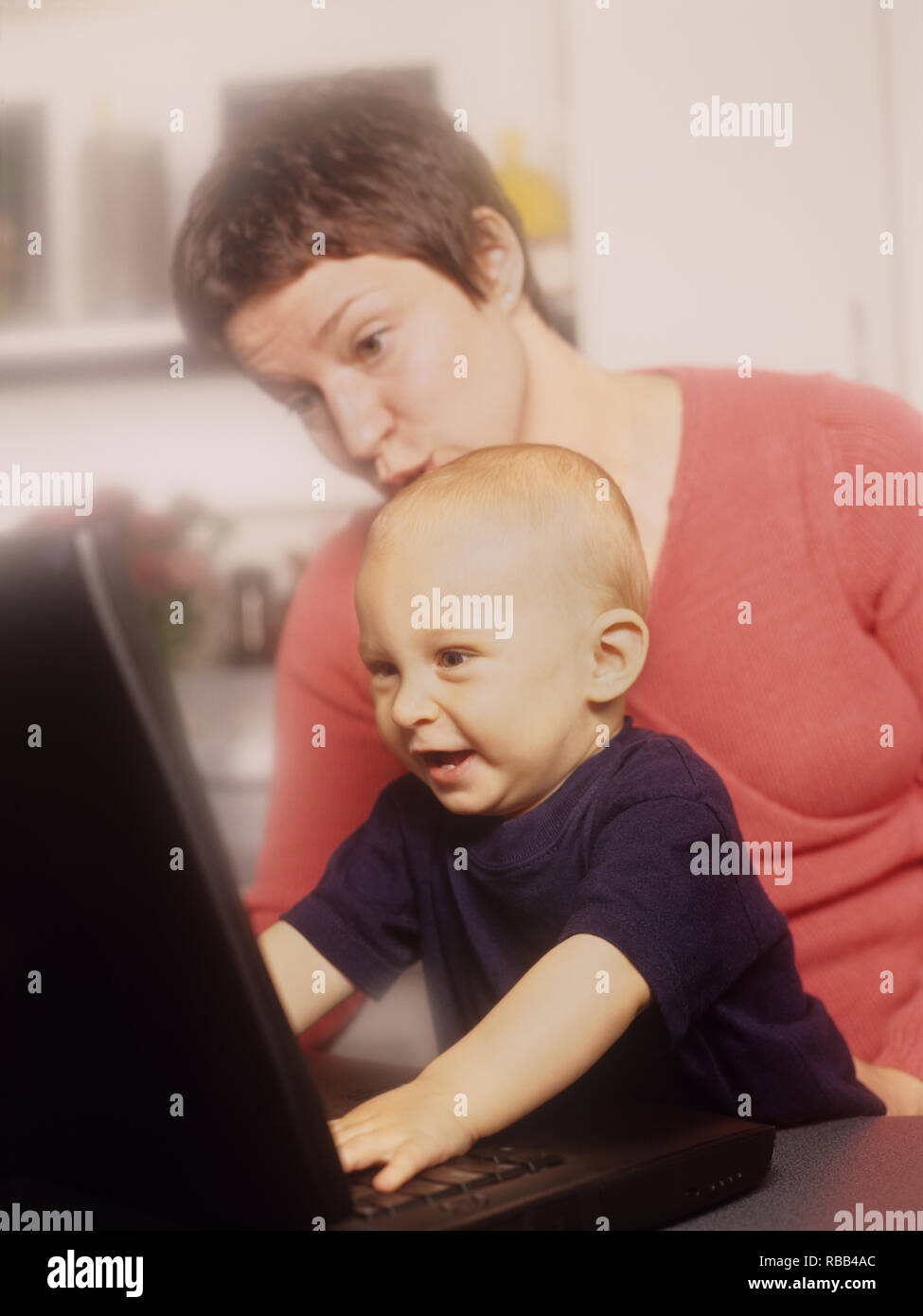 La mère et le petit garçon d'un ordinateur portable avec écran de temps ensemble Banque D'Images