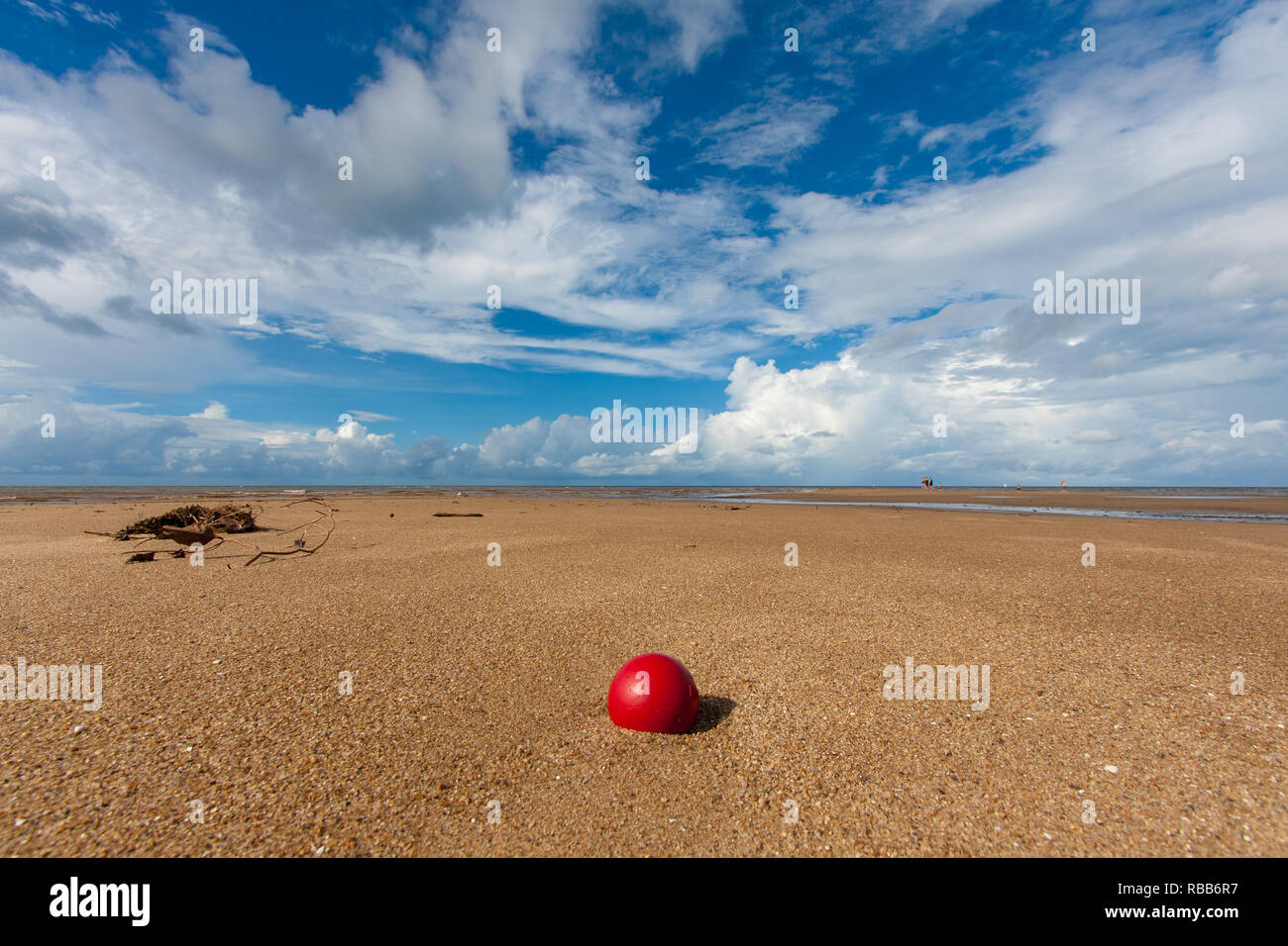 Un filet de pêche rouge bille se trouve isolé sur une plage tropicale Banque D'Images