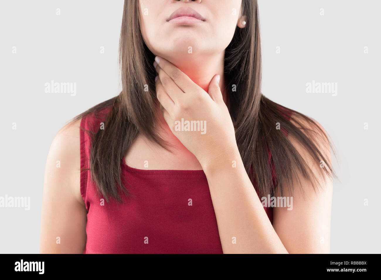 Femme Asiatique avec un mal de gorge ou de glande thyroïde contre l'arrière-plan gris. Reflux acide ou des brûlures d'estomac, douleur au cou, les gens problème corps concept Banque D'Images
