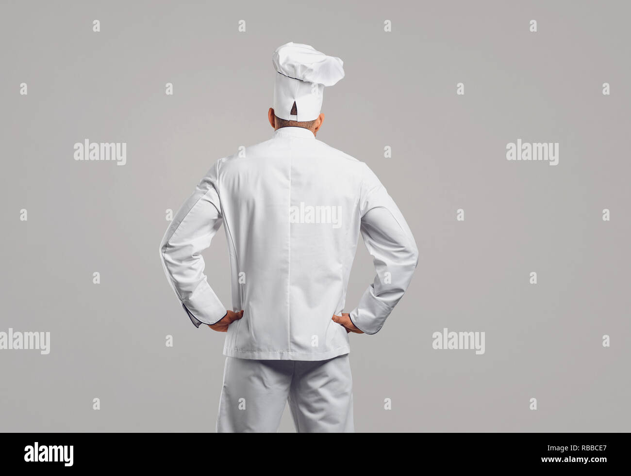 Chef cuisinier en uniforme blanc debout dos afficher . Banque D'Images