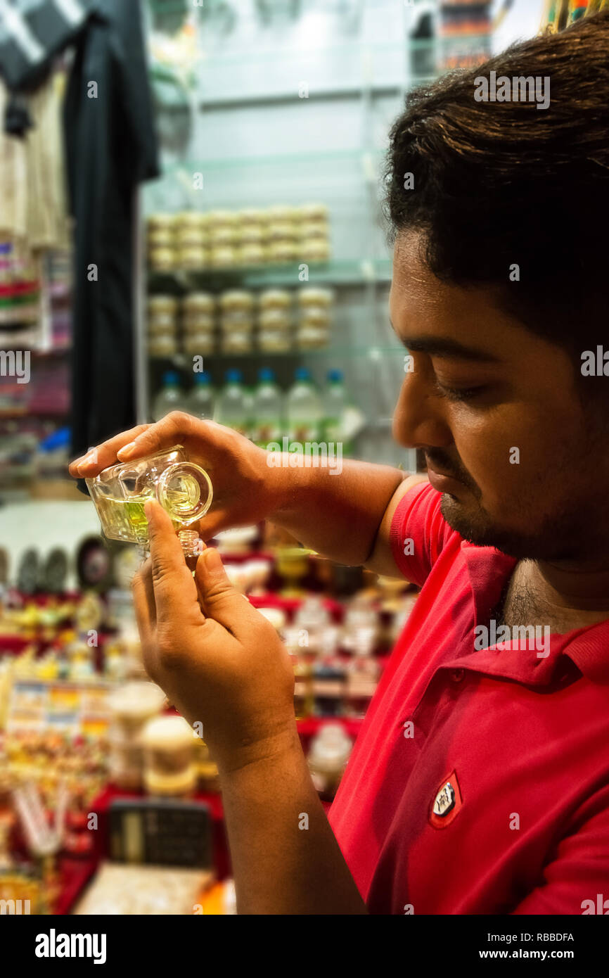 Muscat, Oman - 31 octobre 2018 : Vendeur de remplir une petite bouteille de parfum dans le souk de Mutrah à Muscat Banque D'Images