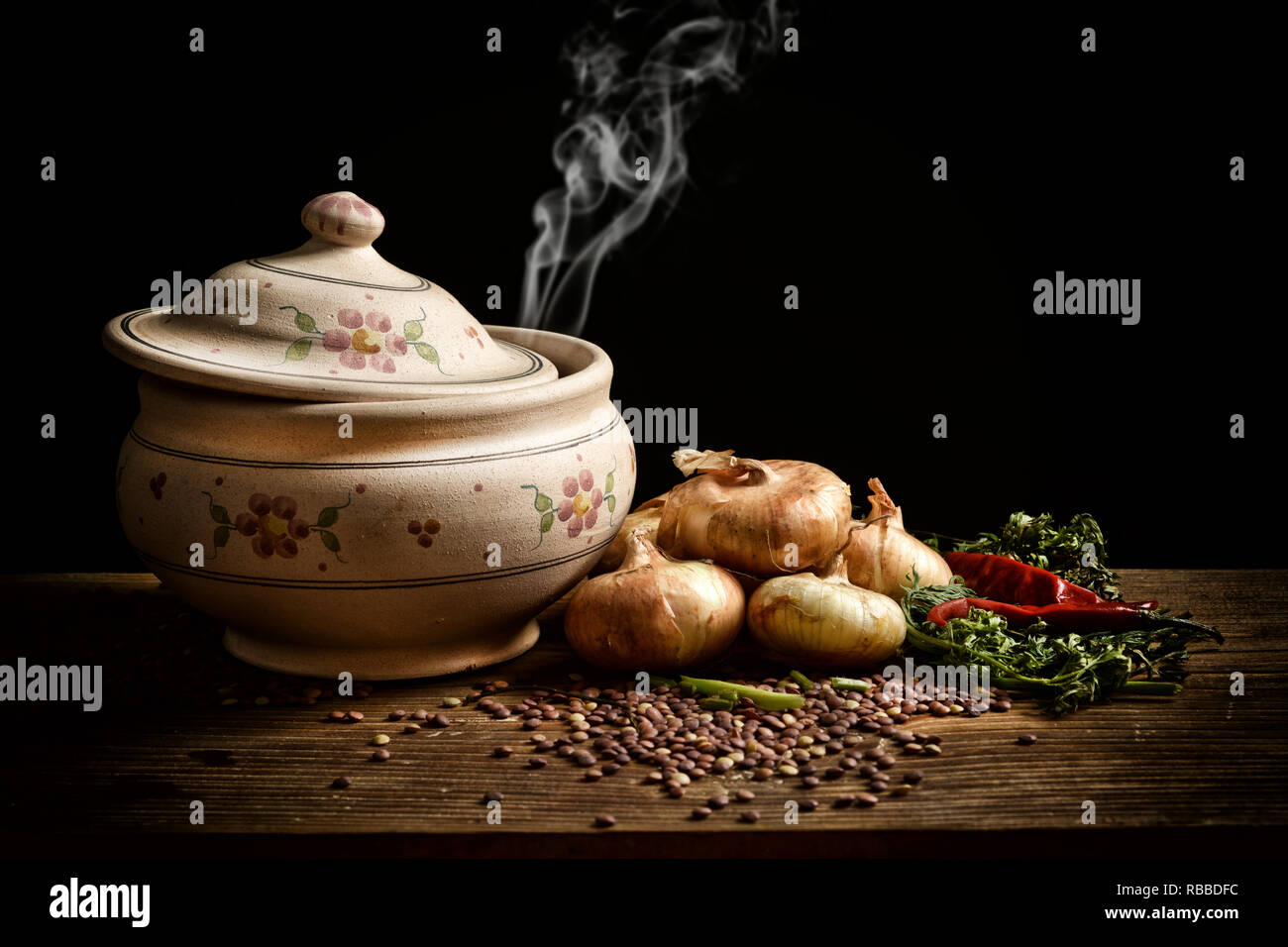 Soupe de lentilles dans le bol en terre cuite avec des ingrédients autour sur fond noir - libre Banque D'Images