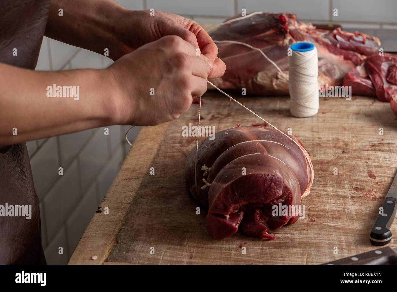 La préparation de la viande de venaison boucher au Gog Farm Shop, Stapleford, Cambridge, Cambridgeshire Banque D'Images