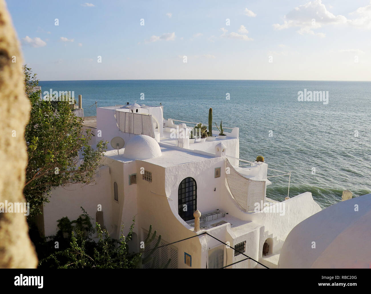 Maison blanche avec dôme sur la plage rocheuse de Hammamet à côté du mur de la forteresse. Belle vue sur la mer. Banque D'Images