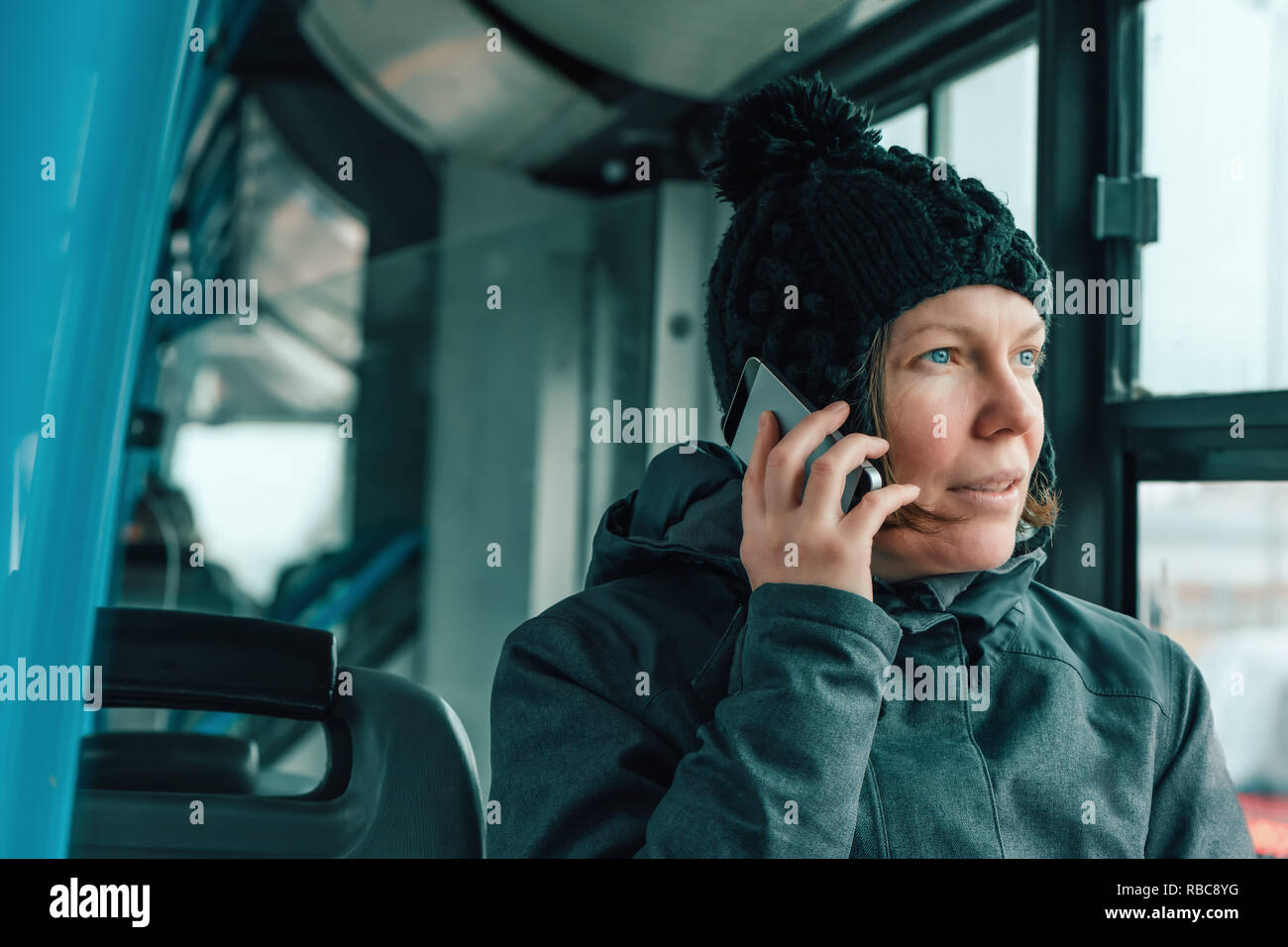Belle hot Woman talking on mobile phone dans les bus dans l'après-midi d'hiver froid Banque D'Images