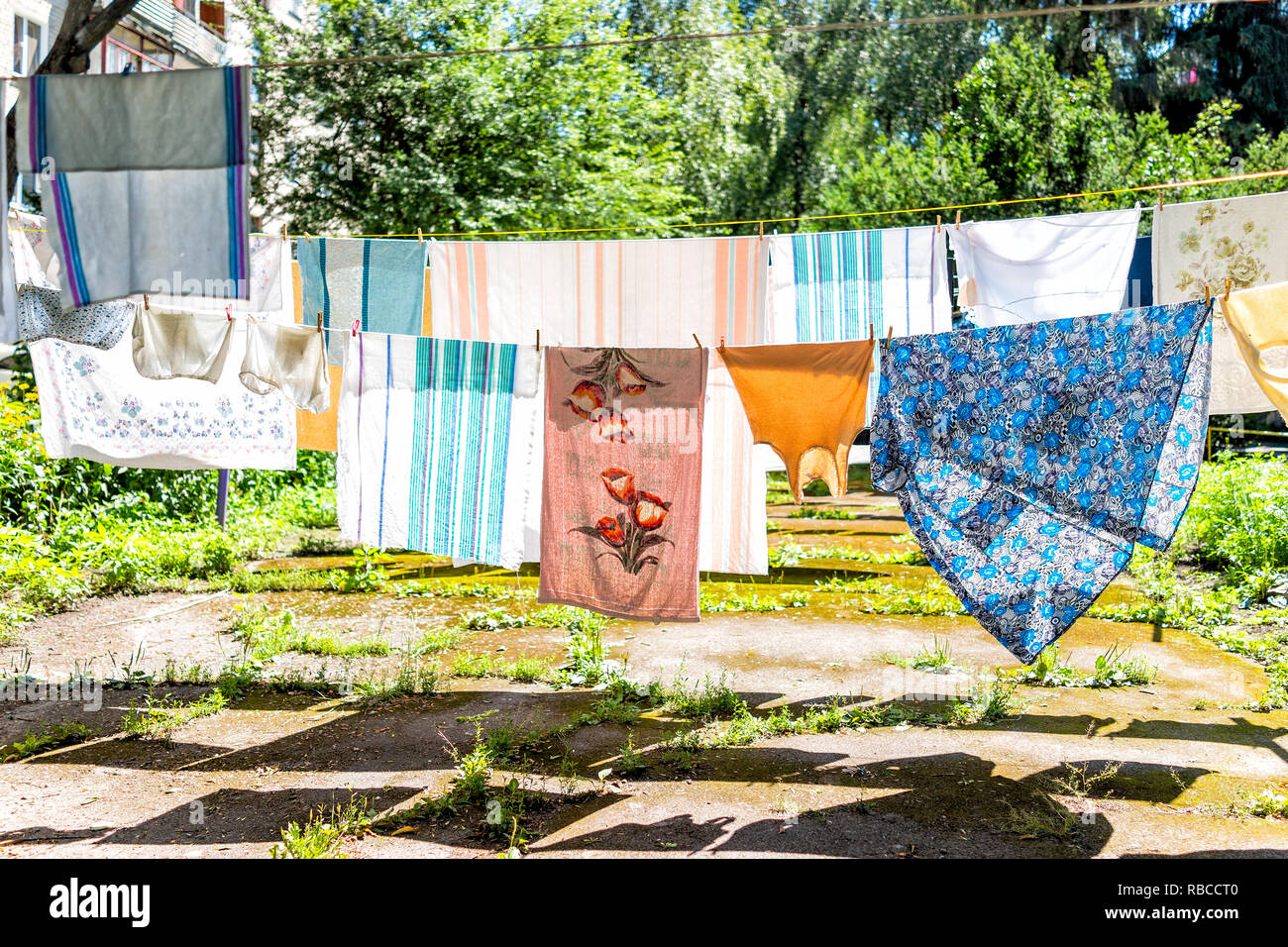 Beaucoup d'étendage en jardin d'été avec shirts colorés sur une grille de séchage en Ukraine ou en Russie soviétique par les immeubles à appartements Banque D'Images