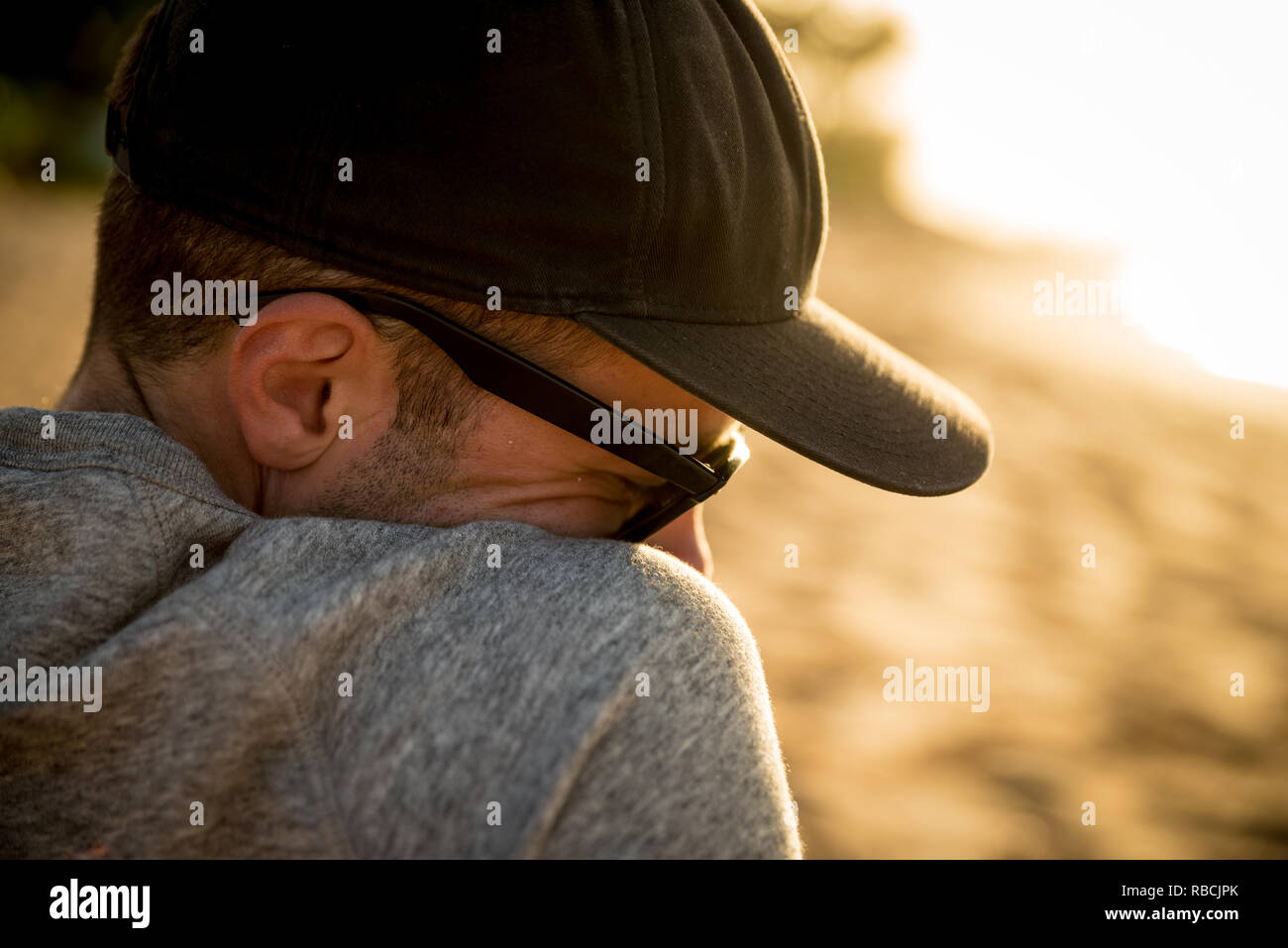 Profil de l'épaule et la tête libre de beau mâle avec chapeau et lunettes de soleil sur la plage à Hawaii Banque D'Images