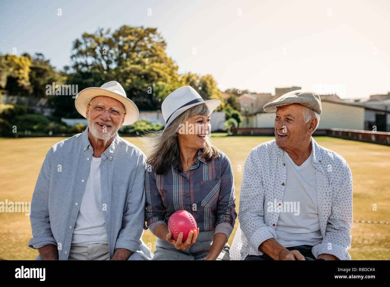 Hauts femme assise avec son ami boules dans la main. De vieux amis assis ensemble sur un banc dans un parc et de parler. Banque D'Images
