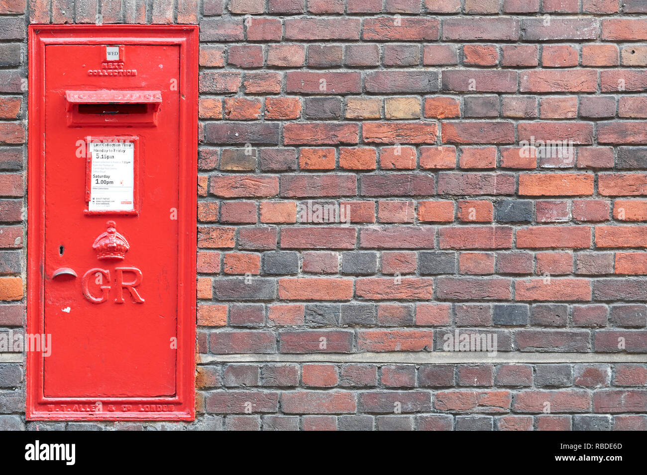 Red post box encastrée dans un mur de brique extérieur du Sidney Sussex College, Université de Cambridge, Angleterre. Banque D'Images