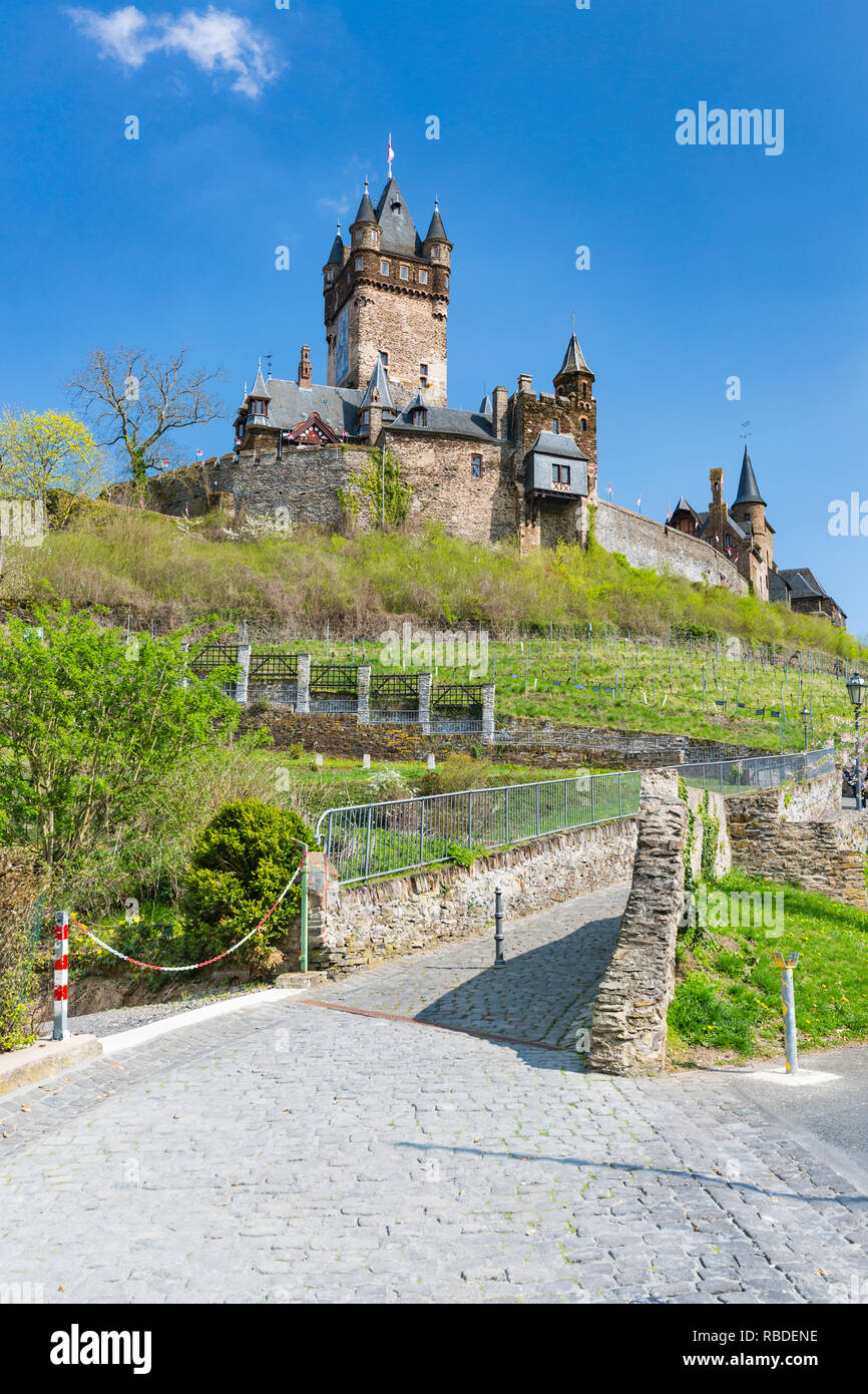 Portrait du célèbre château Reichsburg Cochem, dans l'Eifel en Moselle en Allemagne avec ciel bleu et a ouvert la route ascendant au premier plan. Banque D'Images