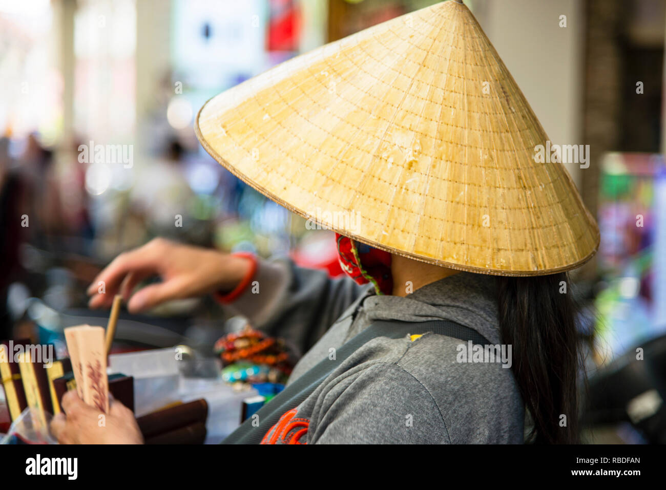 Chapeaux coniques au Vietnam, le nón lá, chapeau de feuille, forme un cône  circulaire parfait qui se couche de la base à l'apex, porté ici par un  vendeur de ventilateur Photo Stock -