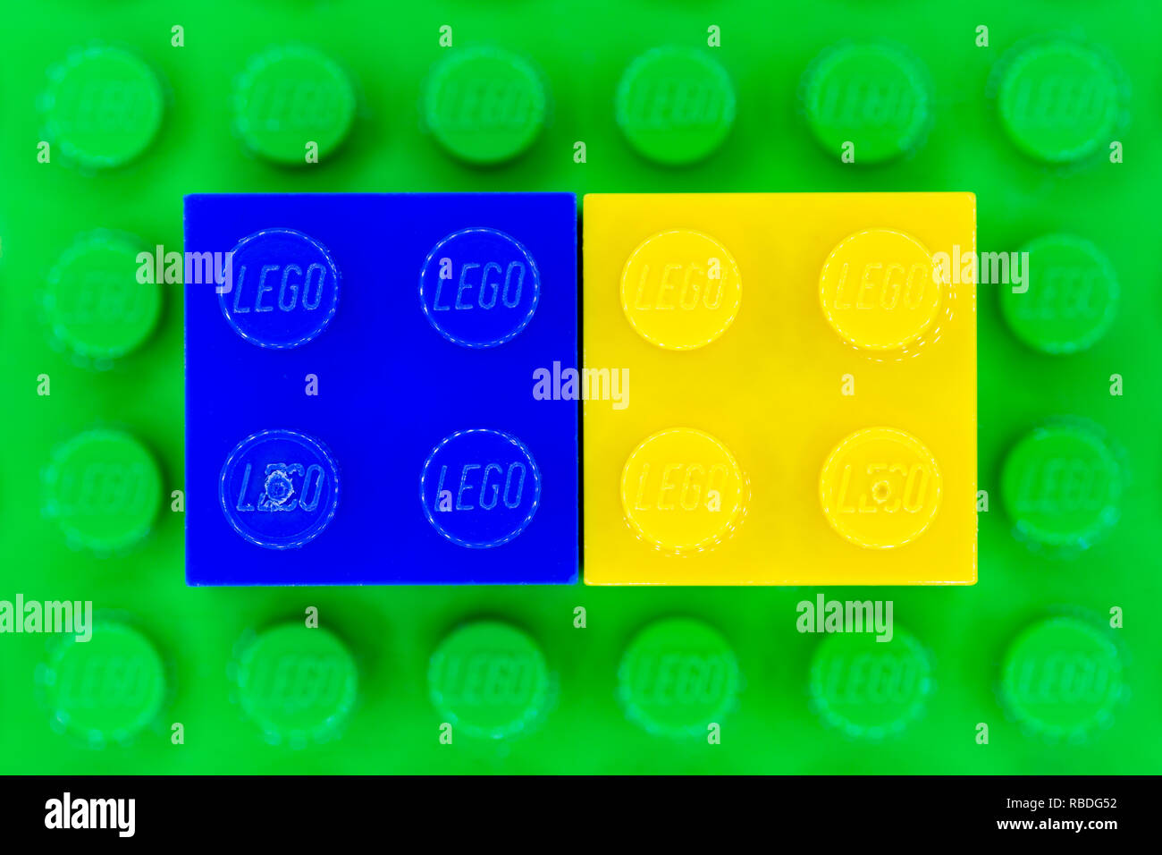 Bleu et jaune 2x2 briques Lego sur une base Lego vert Banque D'Images