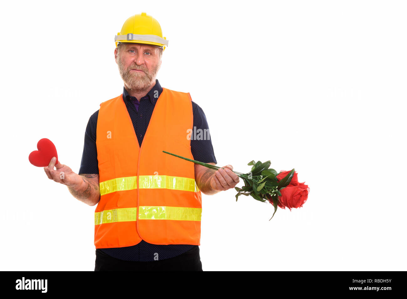 Triste homme barbu d'âge mûr construction worker holding red Heart et Banque D'Images