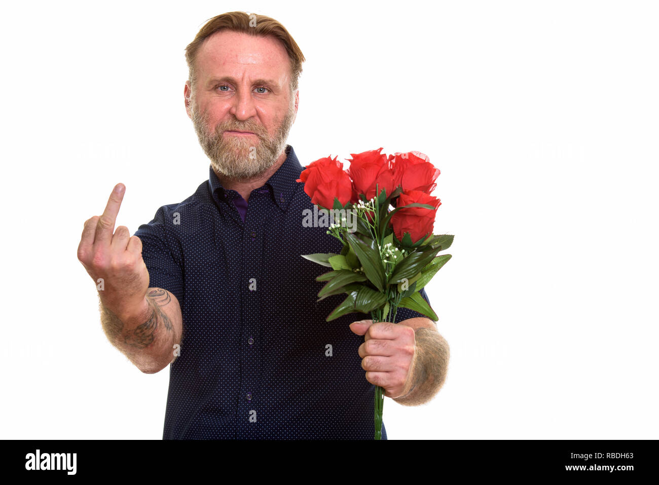 Homme barbu d'âge mûr holding red roses, tout en montrant le majeur Banque D'Images