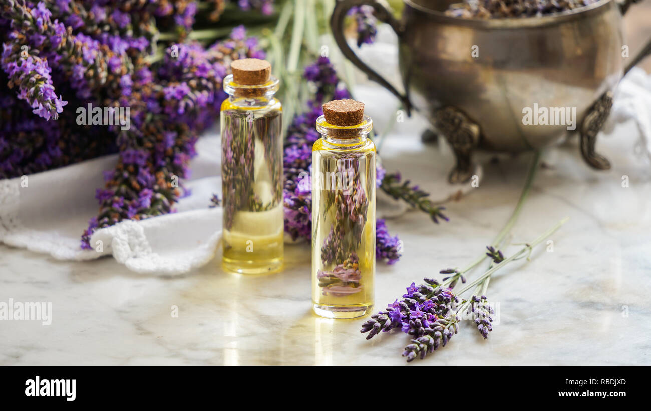 Bouteilles d'huile de lavande, d'herbes naturelles consept cosmétiques fleurs de lavande avec flatlay sur fond de pierre Banque D'Images