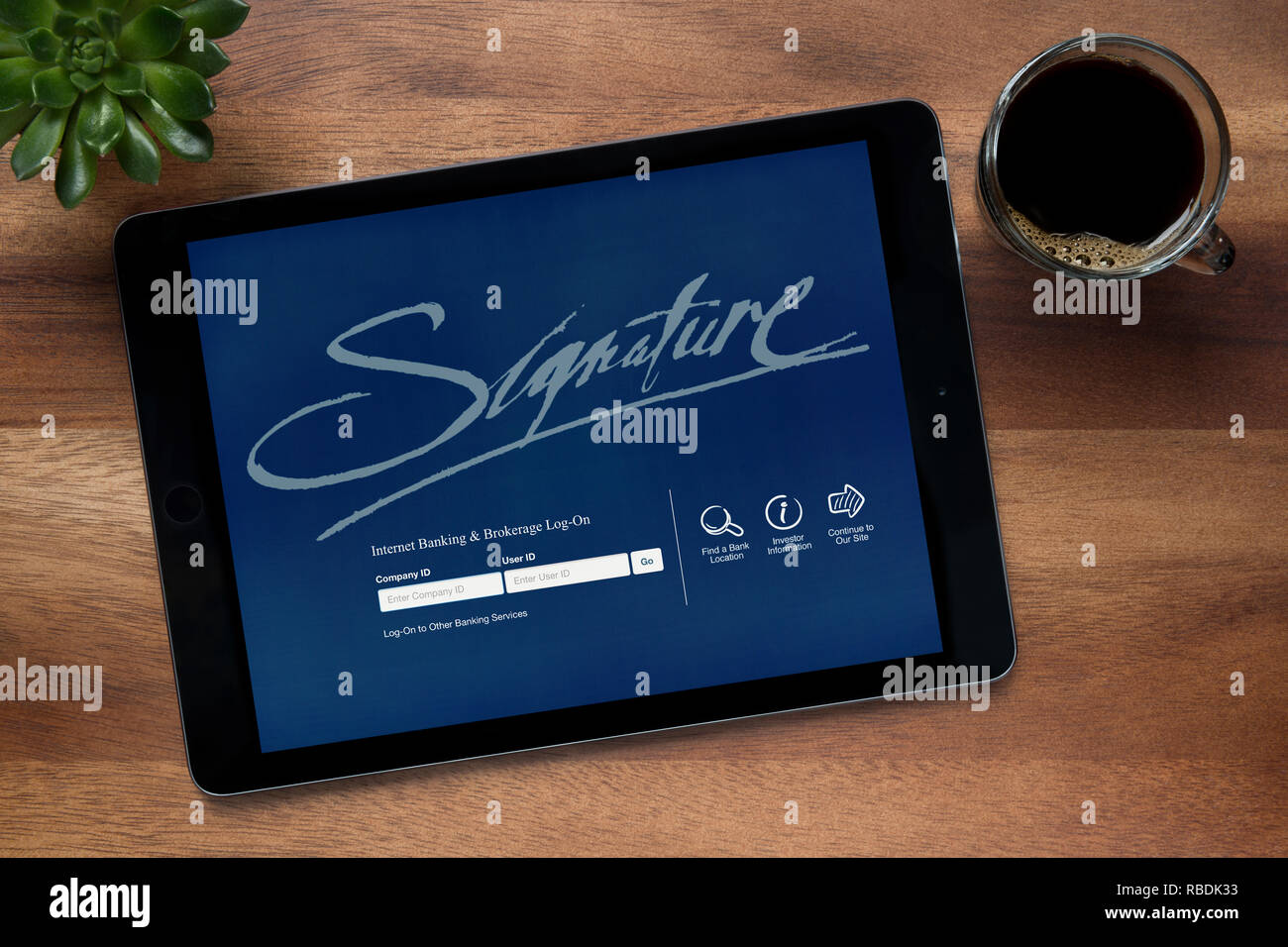Le site web de la signature bancaire Internet est vu sur un iPad tablet, reposant sur une table en bois (usage éditorial uniquement). Banque D'Images
