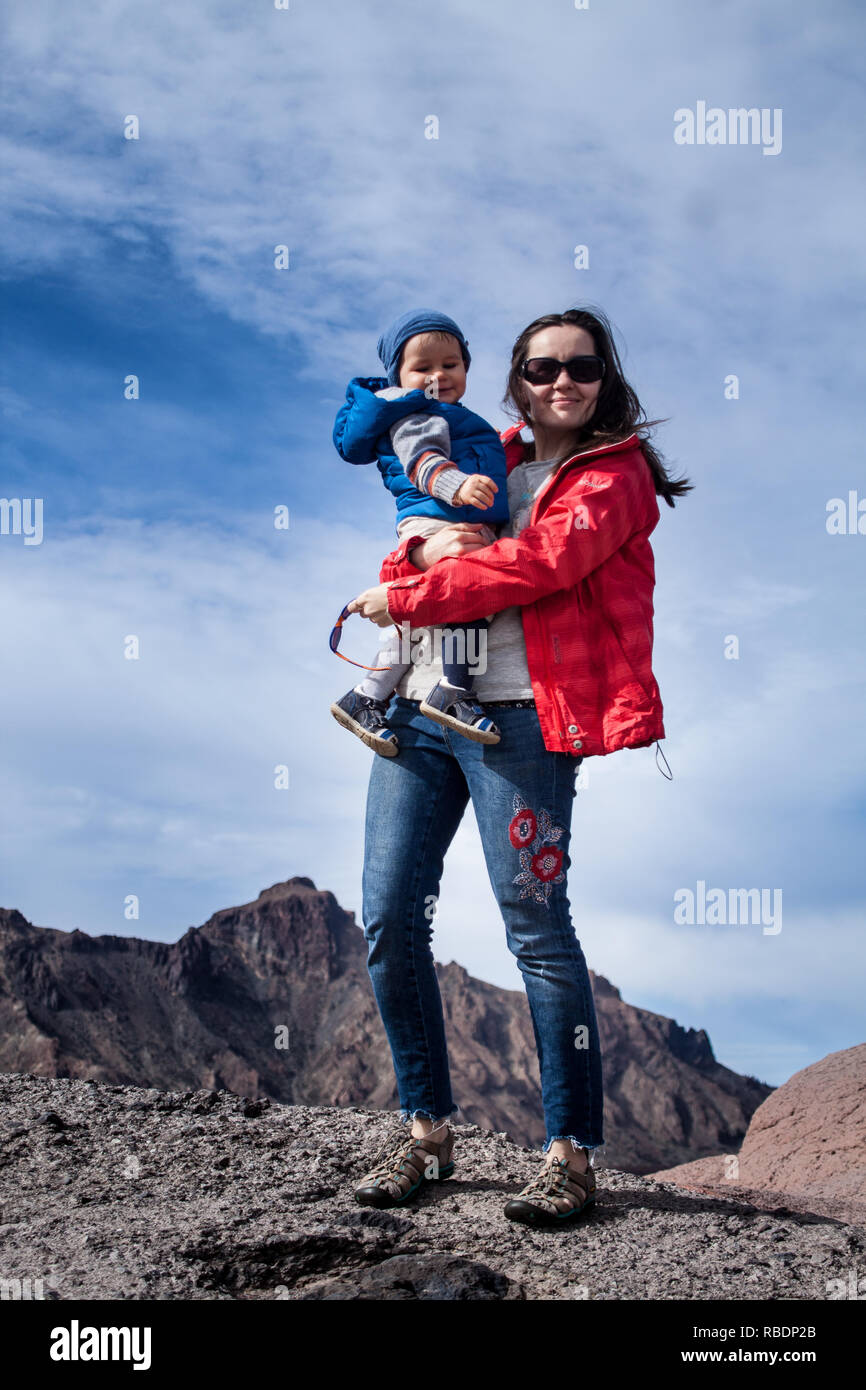Une belle photo d'une belle femme et son fils debout sur une montagne de l'arrière-plan d'un ciel nuageux Banque D'Images
